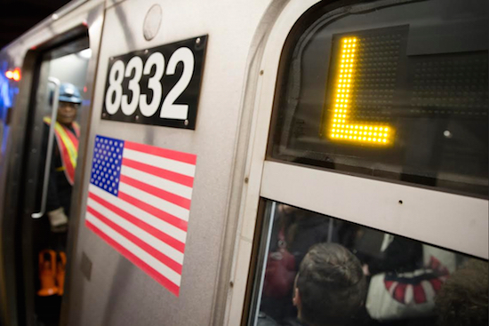 Riders stand inside an L-Train subway car. AP Photo/John Minchillo