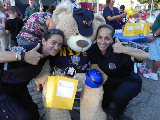 At the 2015 National Night out event, 68th Precinct Police Officers Susan Porcello (left) and Jennifer Cordero playfully posed with Capt. Ray Bear, one of the raffle prizes. Eagle file photo by Paula Katinas