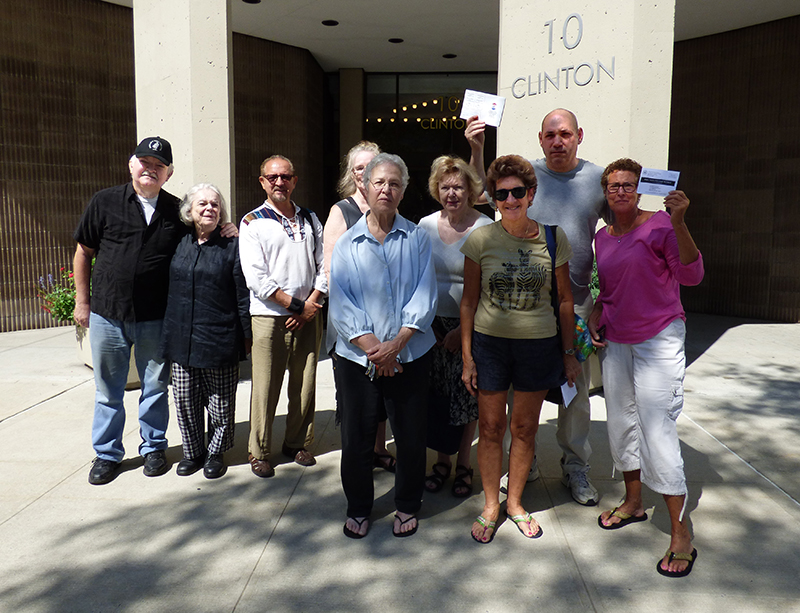 A group of residents of 10 Clinton St. residents met with reporters on Monday to describe their fears they won’t be able to make it to their polling place for the upcoming election. Some of them are holding notices they received from the Board of Elections. Photo by Mary Frost