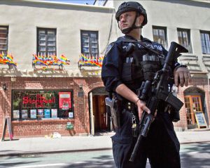 In this June 12 file photo, an armed police officer stands guard outside the Stonewall Inn in Manhattan after a Florida gunman's attack at a gay nightclub spread fear of more attacks. The NYPD plans to distribute 20,000 helmets and 6,000 vests before the end of the year to uniformed patrol officers to protect them better during combat with rampaging shooters. AP Photo/Mary Altaffer, File
