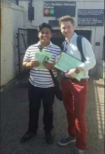 Assembly hopeful Rob Curry-Smithson (right) gets some help on the campaign trail from former student Allen Tapia. The two men distributed campaign literature outside the Fort Hamilton Parkway subway station. Photo courtesy of Rob Curry-Smithson