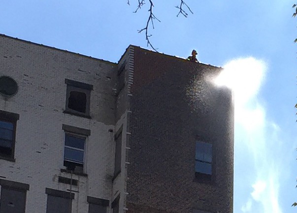 A firefighter can be just seen on the roof of the smoking Polhemus building. Photo courtesy of a Brooklyn Eagle contributor