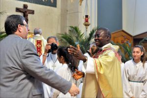 Fr. Gerald Emem Umoren shakes hands with a well-wisher. Photos by Arthur DeGaeta
