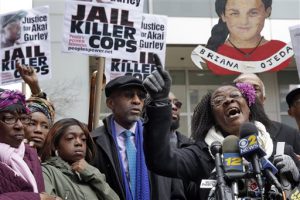 Hertencia Petersen, right, aunt of Akai Gurley, and Melissa Butler, third left, his girlfriend, attend a protest in Brooklyn on, March 24. New York City reached a $4 million settlement in a wrongful death lawsuit filed by the Gurley family. AP Photo/Richard Drew