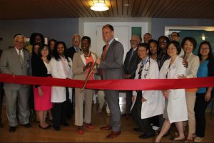 Dr. Kevin Becker, director of Medical Oncology; Jessey Bubb, director of Clinical Services; and other Maimonides staffers perform the ceremonial ribbon-cutting at the entrance to the newly constructed Cancer Center Infusion Suite. Photo courtesy of Maimonides Medical Center
