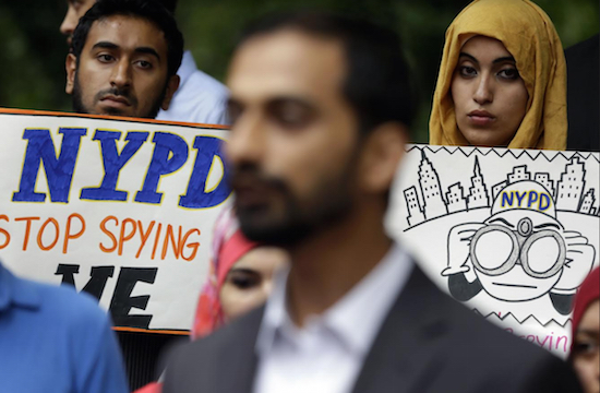 In this 2013 file photo, people hold signs while attending a rally to protest NYPD surveillance tactics near police headquarters in New York. An audit conducted by Inspector General Philip Eure found that the NYPD chronically skirted rules intended to protect political groups from unwarranted government surveillance while investigating Muslims. AP Photo/Seth Wenig, File