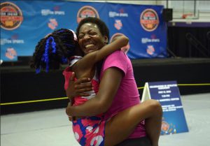 Juennes Track Club athlete Rainn Sheppard, 10, left, of Brooklyn, shares a hug with her mom, Tonia Handy, who surprised Rainn by showing up to watch her compete in the Junior Olympics. Jerry Baker/Houston Chronicle via AP