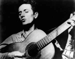 American troubadour Woody Guthrie playing his guitar. AP Photo/File