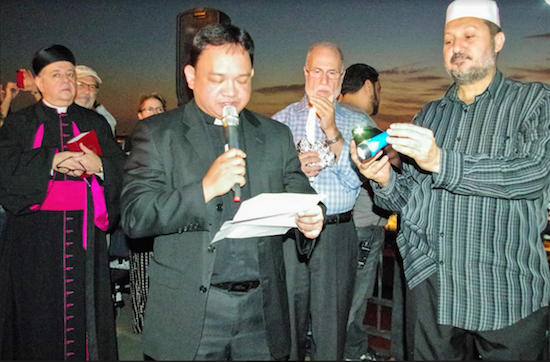 Faith leaders from the Brooklyn Heights Clergy Association participate in a Sept. 11, 2014 memorial service on the Promenade. Foreground, left to right: Msgr. James Root, Fr. Joseph Hugo (holding microphone), Dr. Ahmad Jaber (holding candle) and Imam Abdallah Allam. Eagle file photo by Francesca N. Tate