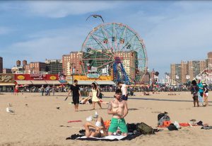 On Labor Day, sunbathers gather on Coney Island though swimming is forbidden due to dangerous riptides. Eagle photos by Lore Croghan