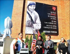 Monsignor David Cassato, pastor of St. Athanasius Church, gives introductory remarks before the unveiling of Mother Saint Teresa’s statue on Sunday. With him are representatives from the Albanian community Kozeta Turishta and Marco Kepi, who is president of the Albanian Roots Organization. Photo by Arthur DeGaeta