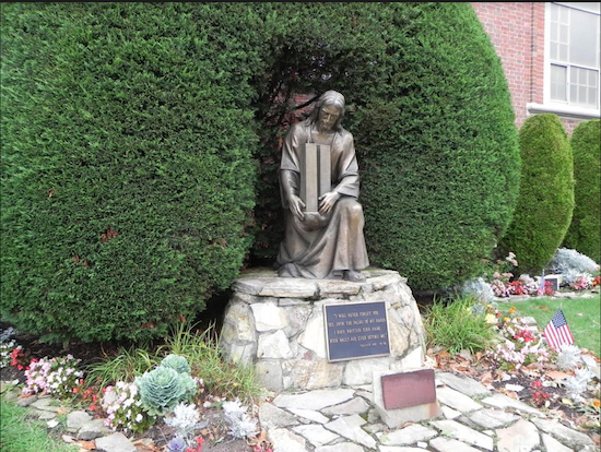 Parishioners at Saint Ephrem Catholic Church in Dyker Heights commissioned this statue of Jesus Christ lovingly holding the Twin Towers and had it erected in a garden outside the church as a tribute to the parishioners killed on Sept. 11. Eagle photo by Paula Katinas