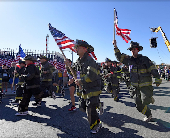 Flag-toting firefighters in full emergency response regalia take off from their starting point in Red Hook. Eagle photos by Andy Katz
