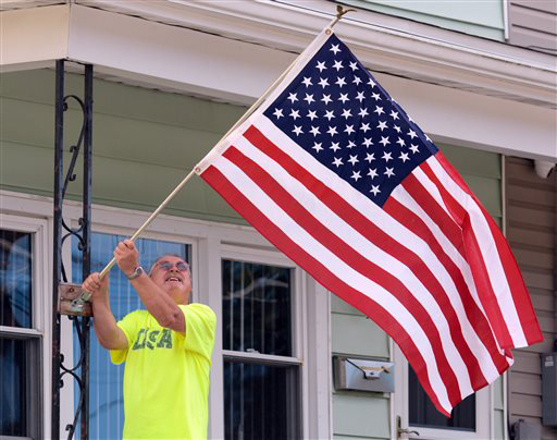 Veteran Bill Bildheiser, of Palo Alto, PA., hangs an American flag outside his home. AP photo by David McKeown