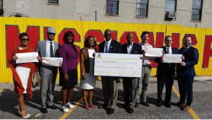 Brooklyn Borough President Eric Adams, fourth from right, and several elected officials, community activists and developers' representatives display a mock check for $2,250,000 as Adams announces his Faith-based Development Initiative in the parking lot of Calvary Community Church in Crown Heights. Eagle photo by James Harney