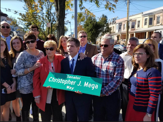 Councilmember Vincent Gentile (center) holds the new street sign as members of the Mega family join in. Photo courtesy of Gentile’s office