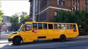 A Jofaz Transportation Co. school bus sits outside P.S. 118 on Fourth Avenue in Park Slope after dropping off schoolchildren Tuesday morning. A tentative contract agreement Monday night averted a threatened strike by nearly 900 drivers for Jofaz and Y&M bus companies. Eagle photo by James Harney
