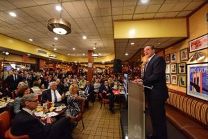 Gov. Andrew Cuomo addresses an audience at Junior’s with Friday Breakfast host Steven Cohn, far left, and Democratic Party Chair Frank Seddio, left. Eagle photos by Andy Katz