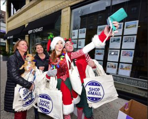 From left: Montague Street BID Chair Kate Chura, mascot Wiley, BID member Deanna Rasa, Emily Season and Kirk Bixby take the first selfie with elves of the day. Eagle photos by Andy Katz