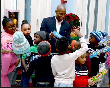 Brooklyn Borough President Eric Adams passes out presents at Brooklyn Borough Hall to young Brooklynites. Photo courtesy of Stefan Ringel/Brooklyn BP’s Office