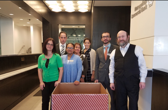 Staff members at the bank’s Borough Park branch are ready to receive coats for the coat drive. Photo courtesy of Metropolitan Commercial Bank
