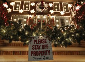 A sign in front of a decorated house warns visitors to keep off the premises in Dyker Heights. While many residents welcome the crowds that flock to the area to see over-the-top Christmas decorations on private homes, not all residents are happy with the hordes of tourists. AP Photos/Kathy Willens