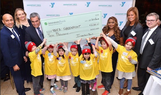 Investors Bank representatives present the bank’s $10,000 donation to the Greenpoint YMCA as children celebrate. Photo by Ken Brown