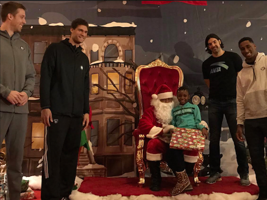 Brooklyn Nets players (from left) Justin Hamilton, Brook Lopez, Luis Scola and Rondae Hollis-Jefferson pose with a little girl and Santa on Tuesday at Atlantic Terminal in Downtown Brooklyn. Photo courtesy of the Brooklyn Nets