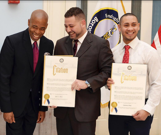 Brooklyn Borough President Eric Adams (left) honored four Brooklyn residents on Wednesday afternoon as part of his continuing “Heroes of the Month” program, where he highlights ordinary Brooklynites who do extraordinary acts. Shown: Adams presents Luis Ruiz (center) and his stepson Antonio Pina with awards for their roles in saving a woman from an attempted rape in East Williamsburg. Photo: Erica Sherman/Brooklyn BP’s Office