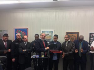Assemblyman Dov Hikind presents hero teen Ahmed Khalifa with a laptop computer as Councilmember Mathieu Eugene (left of Hikind) and community leaders look on. Photo courtesy of Hikind’s office