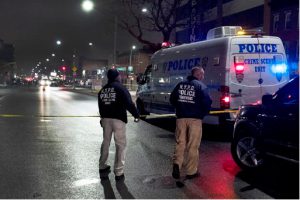A pair of New York City Police Department officers investigate at the scene where a fellow officer shot and killed an armed man, in the Crown Heights section of the Brooklyn borough of New York, Wednesday, Jan. 4, 2017. Officials said plainclothes officers confronted the man as he fired a handgun into a lounge around 3:30 a.m. Wednesday. The NYPD said the man turned the gun on the officers, who fired at him. AP Photo/Mark Lennihan