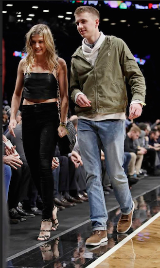 Genie Bouchard walks the court with her blind date John Goehrke, right, during the first half of an NBA basketball game between the Brooklyn Nets and the Milwaukee Bucks Wednesday, Feb. 15, 2017, in New York. After losing a Super Bowl bet on Twitter, Bouchard agreed to go on a date with a random fan. AP Photo/Frank Franklin II