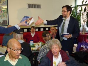 State Sen. Daniel Squadron kicked off a tour of Brooklyn senior centers on Tuesday to organize older adults to fight Gov. Andrew Cuomo’s budget cuts to the centers. Above: Squadron distributes information booklets to seniors at St. Charles Jubilee Senior Center in Brooklyn Heights. Photos by Mary Frost