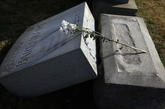 Flowers rest on a headstone at Mount Carmel Cemetery Feb. 28 in Philadelphia. Volunteers helped clean up and restore the Jewish cemetery where vandals damaged hundreds of headstones. Under the IDC’s proposal, a special crime category would be created for desecrating a cemetery. AP Photo/Jacqueline Larma
