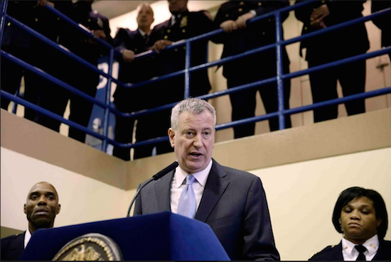 In this March 12, 2015 file photo, New York Mayor Bill de Blasio is surrounded by corrections officers as he speaks at a news conference at the Rikers Island prison in New York. Gov. Andrew Cuomo and some activists say shutting down Rikers is the only solution for a cycle of abuses that includes violence by guards and gang members, mistreatment of the mentally ill and juveniles and unjustly long detention for minor offenders. But de Blasio is against a shutdown, saying reforms and improvements would cost le