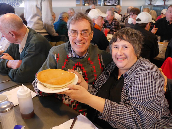A couple happily holds up a late of giant pancakes for the camera. Eagle photo by Arthur De Gaeta