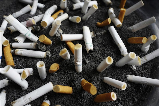 In this April 7, file photo, cigarette butts are discarded in an ashtray outside a New York office building. New York City Mayor Bill de Blasio announced a plan on Wednesday to raise the price of a pack of cigarettes from $10.50 to $13 in the city. AP Photo/Mark Lennihan, File