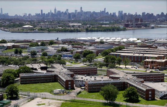 In a June 20, 2014, file photo, the Rikers Island jail complex stands in New York with the Manhattan skyline in the background. Mayor Bill de Blasio is intent on closing the sprawling facility, but state Sen. Marty Golden has expressed concerns over public safety. AP Photo/Seth Wenig, File