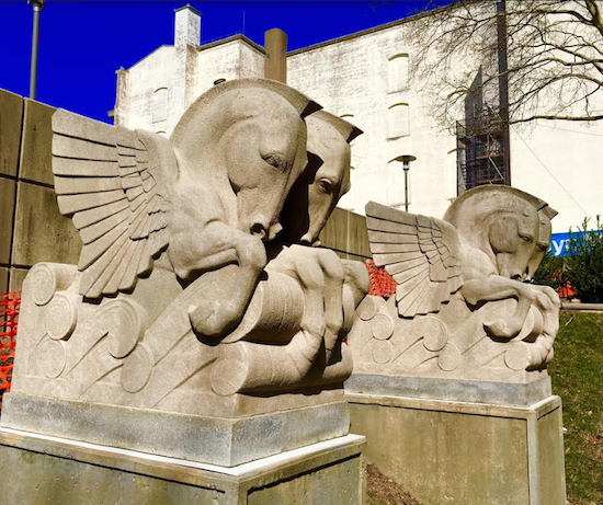 The Brooklyn Eagle enthusiastically backs an idea by readers to temporarily move the classic stone friezes currently gracing the façade of the Brooklyn Heights Library (above left) to the Brooklyn Museum’s Sculpture Garden (above right). Eagle file photo by Lore Croghan