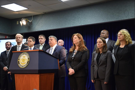 Acting District Attorney Eric Gonzalez (standing at the podium) is shown at a press conference to announce the charges against a construction company owner, whom they allege is responsible for the death of a poorly trained 18-year-old construction worker. Photos courtesy of the DA’s Office