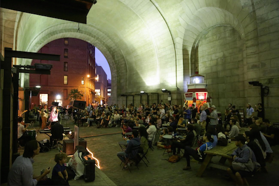 Spectators gather to watch an evening performance under the Manhattan Bridge. Photo by Tory Williams