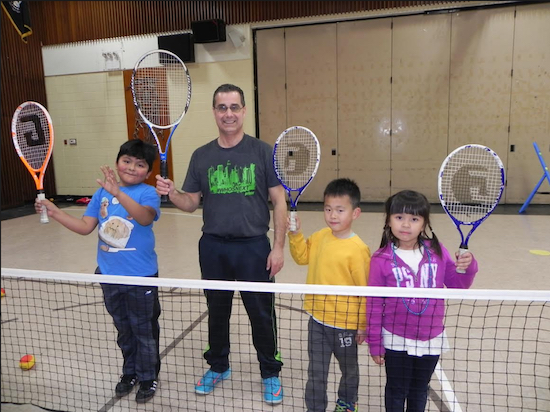 Tennis instructor Jim DiGiacomo shows Richie Zempoaltecat, Ellis Wan and Shucheng Liao (left to right) the finer points of the game at a recent session of the after-school program. Eagle photo by Paula Katinas