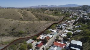 This Sunday, April 2, 2017 file photo made with a drone shows the U.S. Mexico border fence as it cuts through the two downtowns of Nogales. AP Photo/Brian Skoloff, File