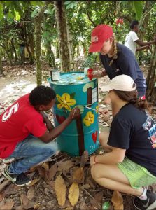 Fontbonne students Lauren O'Keefe and Kaylin O'Malley help paint trash cans in the Dominican Republic to bring awareness to the importance of proper garbage disposal. Photo courtesy of Fontbonne Hall Academy