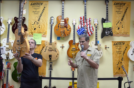 Rocky Schiano holds up a guitar made by Stephen Stern from reclaimed Brooklyn wood. Photo by Jimmy Coppola