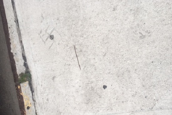 A vandal carved a swastika into the sidewalk at McDonald Avenue and Avenue W in Gravesend. Photo courtesy of Councilmember Mark Treyger’s office