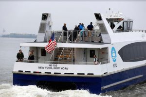 Passengers on board a NYC Ferry watch as the boat departs Sunset Park for Rockaway on May 1. AP Photo by Mark Lenahan