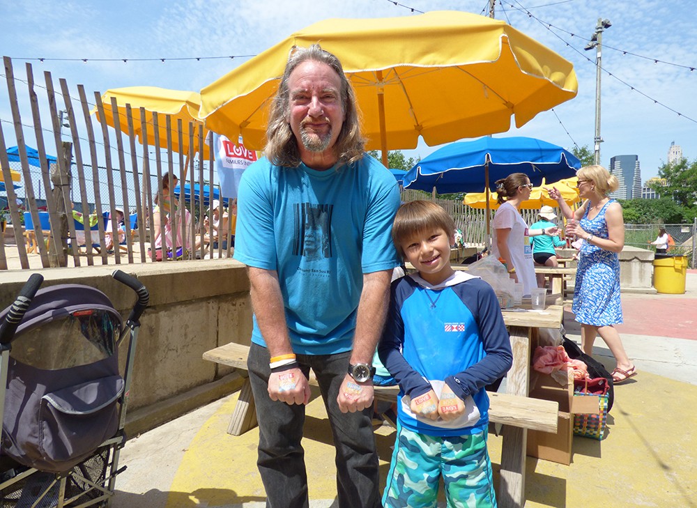 Lee Levine and his son Izzy, almost 8 years old, show off temporary tattoos saying “Love Our Pool.”