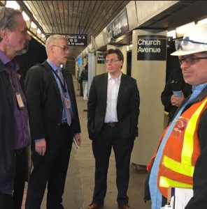 Assemblymember Robert Carroll (center) discusses a repair project at the Church Avenue subway station in Brooklyn with MTA officials. Photo courtesy of Carroll’s office