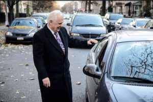 Assemblymember Joseph R. Lentol, pictured chatting with a motorist, says the cleanliness of Greenpoint and Williamsburg streets has led the city to reduce alternate side parking in the two neighborhoods. Photo courtesy of Lentol’s office